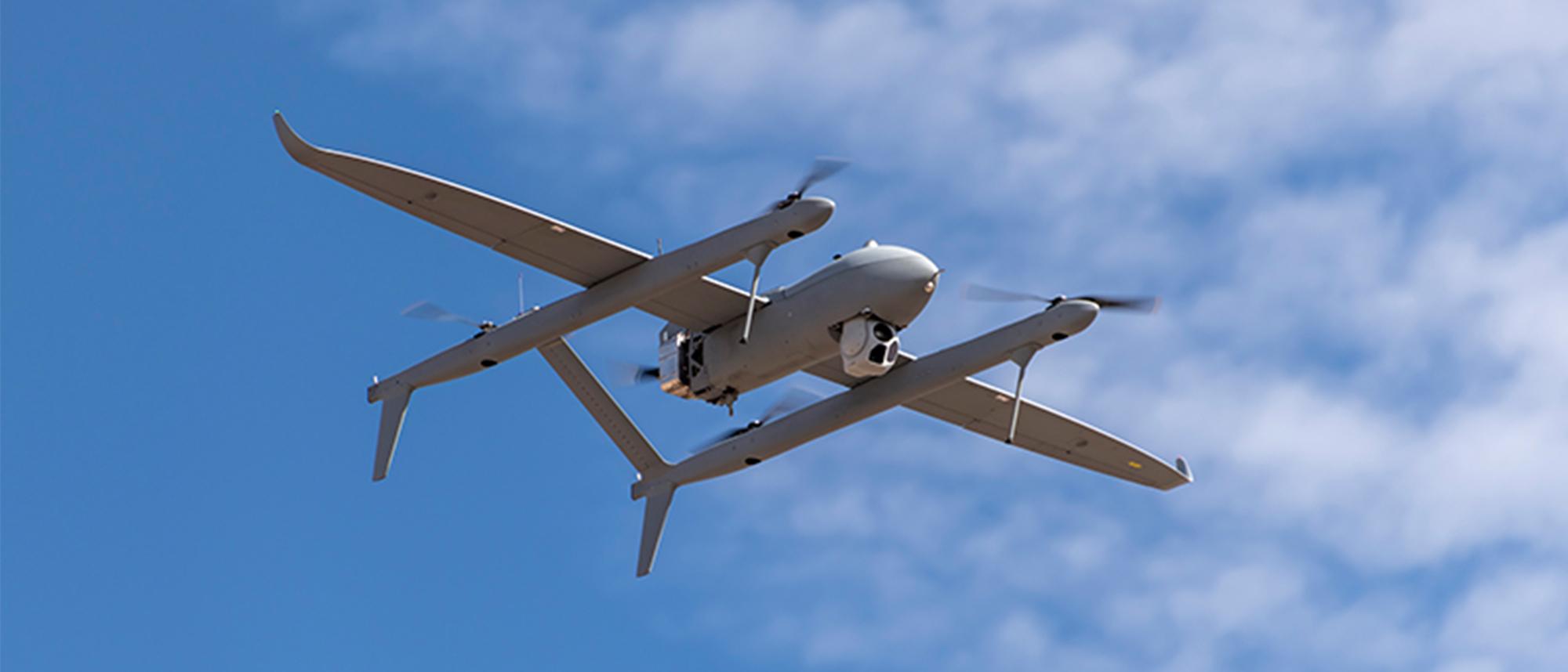 Aerosonde HQ in flight with clouds in the sky