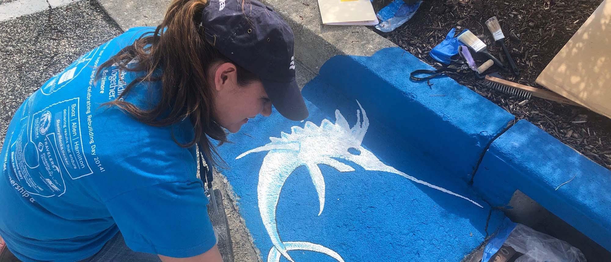 team member painting storm drain