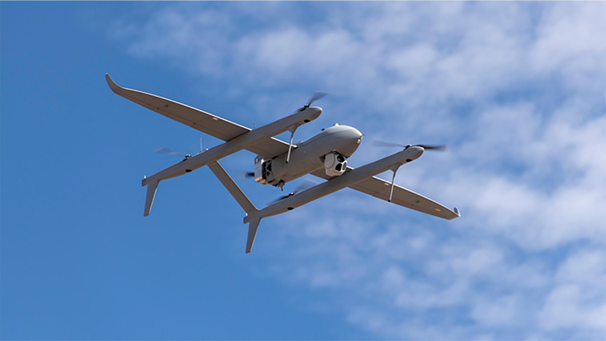 Aerosonde HQ in flight with clouds in the sky