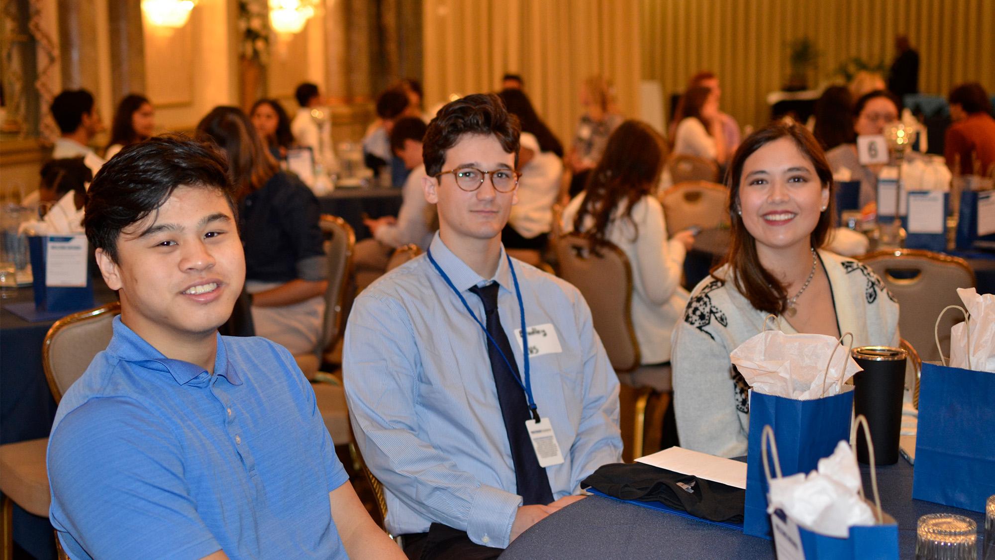 Interns posing at a table, smiling