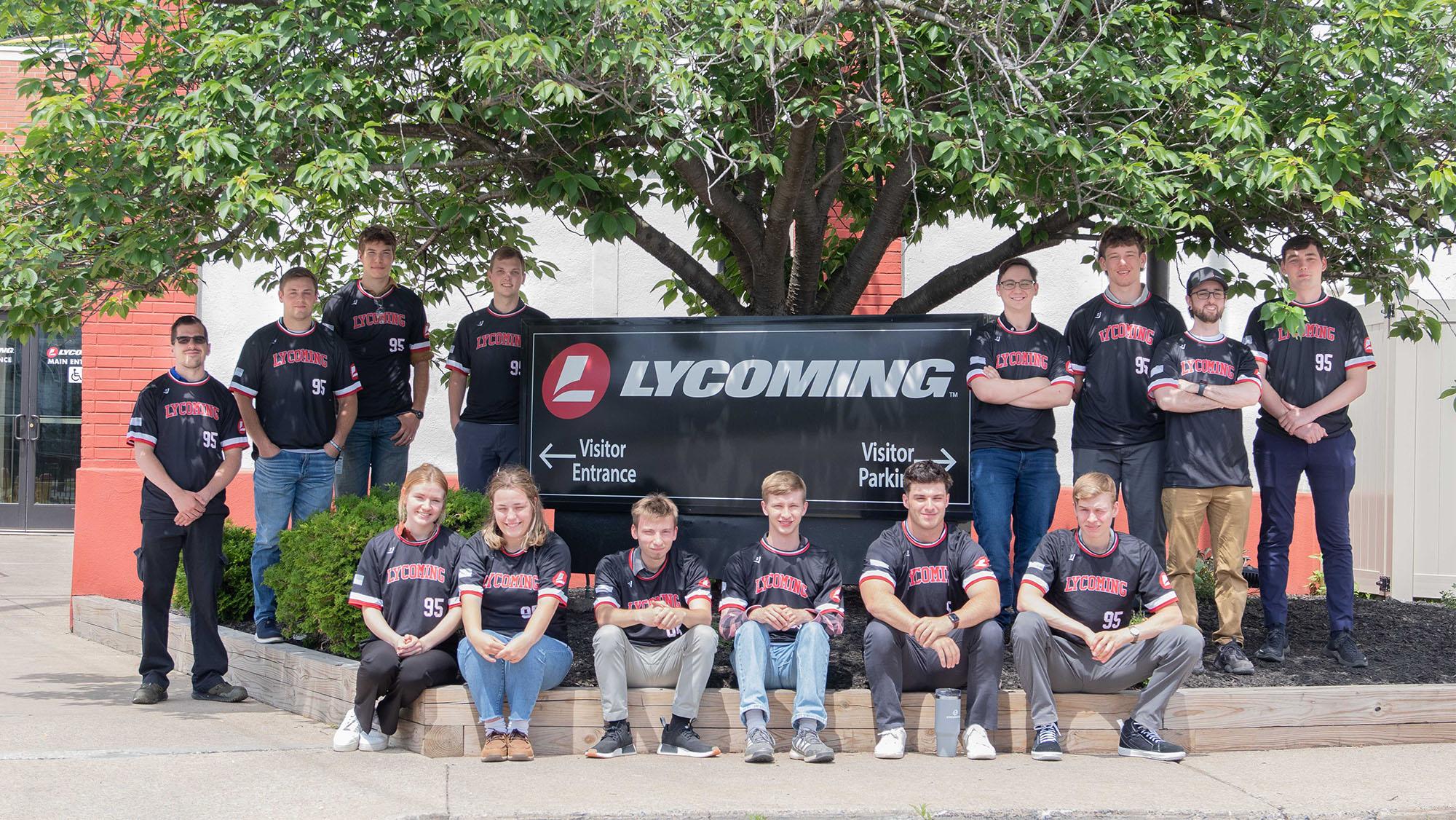Interns posing in front of Lycoming Engines sign in front of building